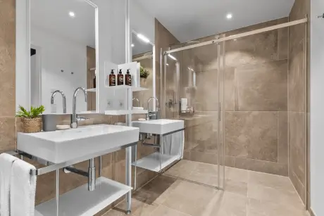 Modernes Hotelbad mit elegantem Waschbecken, Glastdusche und stilvollem Design.
