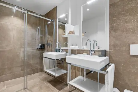 Stilvolles modernes Badezimmer mit Waschbecken und Regendusche im Hotel Stadt Hamburg, Westerland.