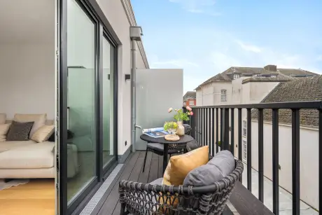 Balkon mit Stühlen und Tisch, ideal für einen Aufenthalt im Hotel Stadt Hamburg in Westerland.