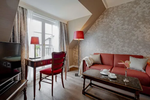 45 m2 Doppelzimmer mit rotem Sofa und Schreibtisch im 12.18. Hotel Stadt Hamburg