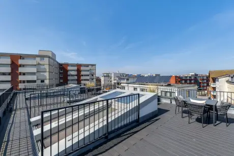 Dachterrasse mit Blick auf moderne Gebäude und Solarpanels in Westerland, Sylt.