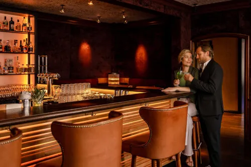 Ein Mann und eine Frau sitzen an der Bar im 12.18. Hotel Stadt Hamburg, Westerland / Sylt