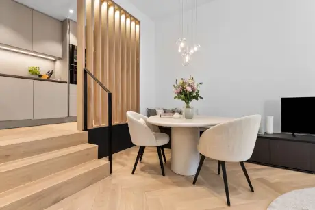 Stylisches Esszimmer im Hotel Stadt Hamburg mit Tisch, Stühlen und frischen Blumen.
