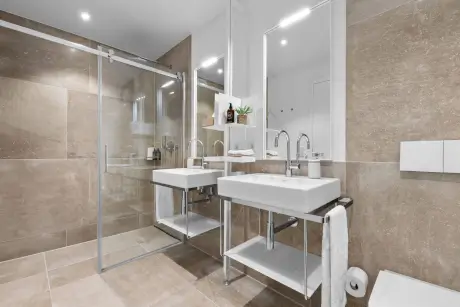 Modernes Badezimmer im Hotel Stadt Hamburg mit eleganten Waschbecken und Glasdusche.