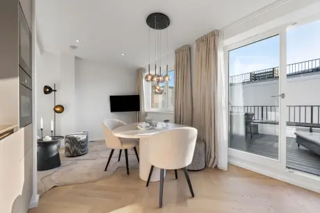 Modernes Hotelzimmer mit Essbereich, stilvollen Möbeln und Blick nach draußen.