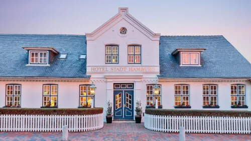 Fassade des Hotels Stadt Hamburg in Westerland, Sylt bei Dämmerung.