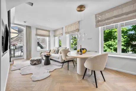 Moderne Hotel-Suite mit elegantem Sofa, Tisch und viel Licht.