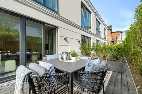 Moderne Hotelterrasse in Westerland mit stilvollen Möbeln und Pflanzen.