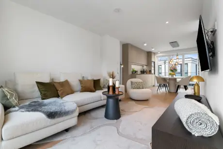 Stilvolles Hotelzimmer mit gemütlichem Sofa, Couchtisch und Fernseher.