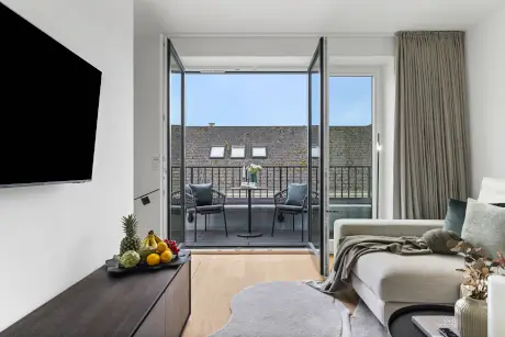 Modernes Hotelzimmer mit Blick auf den Balkon, ideal für entspannende Aufenthalte.