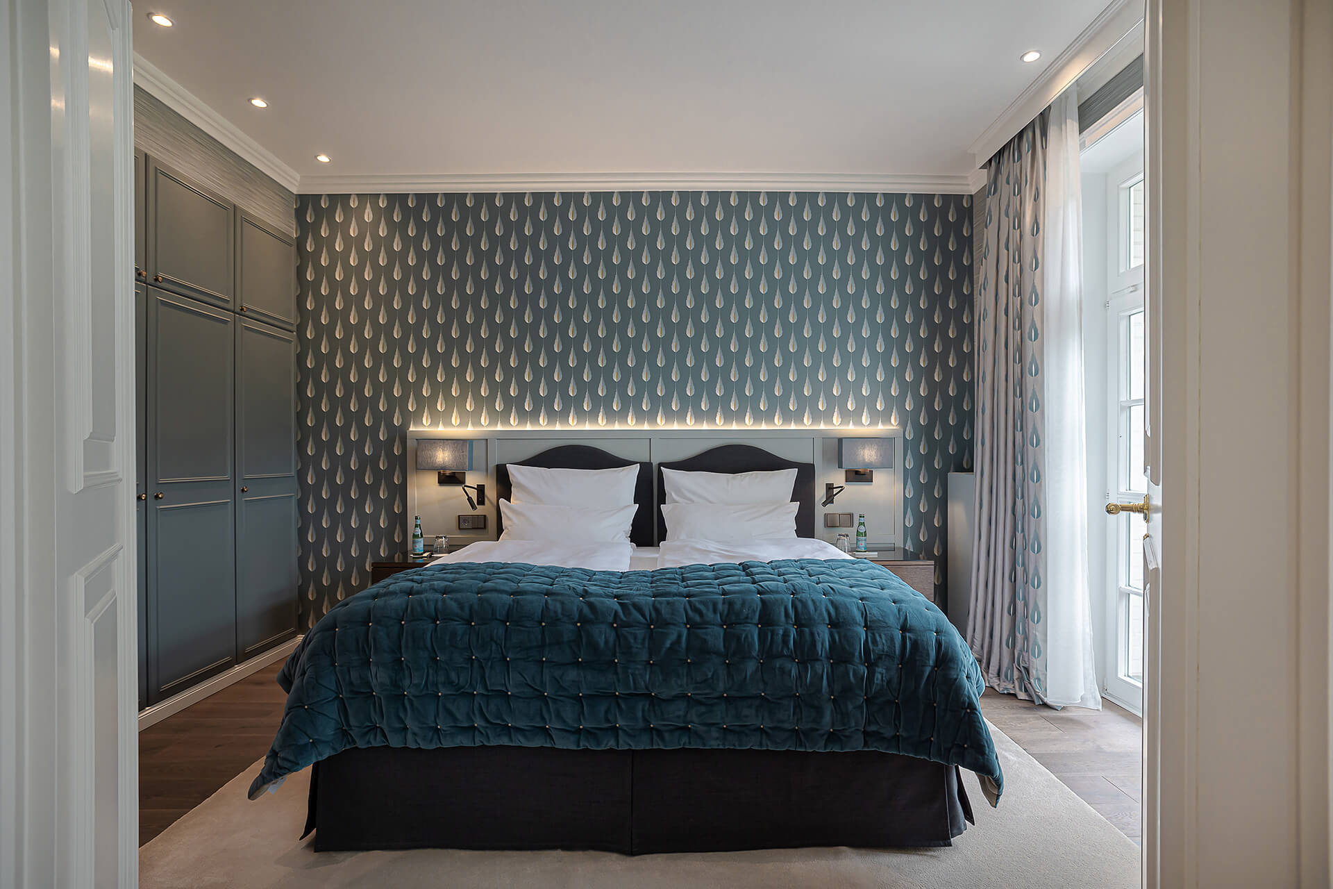 Ein Schlafzimmer mit einem Bett und einer Tapete im Hotel Stadt Hamburg GmbH
