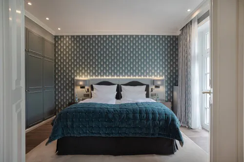 Ein gemütliches Schlafzimmer mit Bett und Tapete, designed von 12.18. Hotel Stadt Hamburg GmbH, Strandstraße 2, 25980 Westerland / Sylt, Deutschland