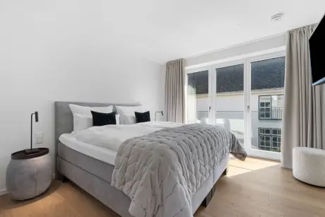 Modernes Hotelzimmer mit einem Doppelbett, großem Fenster und stilvoller Einrichtung.