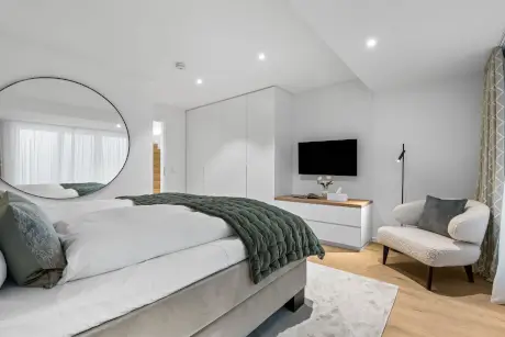 Modernes Hotelzimmer mit Bett, Spiegel und Fernseher in Westerland, Sylt.