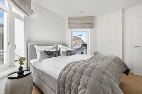 Stylisches Hotelzimmer mit einem großen Bett und Blick auf die Sylt.