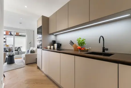 Moderne Küche mit einer Kaffeemaschine und frischen Tomaten, ideal für Hotelaufenthalte.