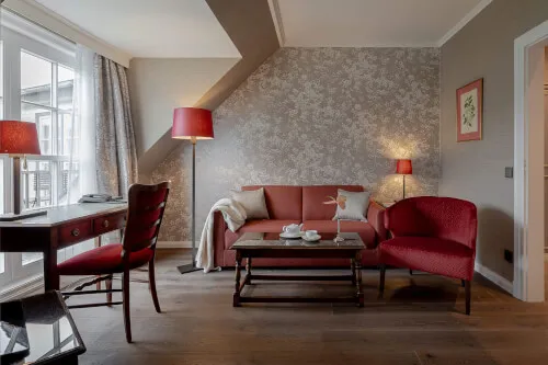 Ein Wohnzimmer mit einem Tisch und Stühlen im Hotel Stadt Hamburg