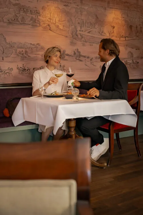 Ein Mann und eine Frau genießen Wein am Tisch im Bistro Stadt Hamburg von Hotel Stadt Hamburg GmbH