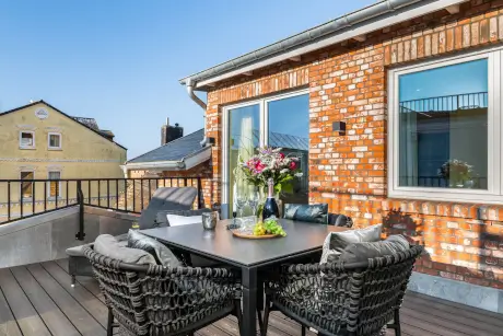Elegante Terrasse mit Esstisch und Blumen im Hotel Stadt Hamburg in Westerland.