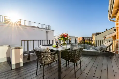 Stylische Terrasse in Westerland mit Tisch, Stühlen und Blumen, ideal für entspannte Stunden.