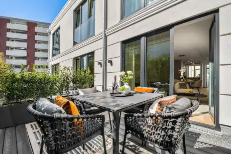 Terrasse des Hotel Stadt Hamburg mit stilvollem Tisch, bequemen Stühlen und Pflanzen.