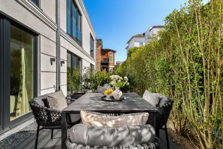 Moderne Außenterrasse mit Tisch und Stühlen, umgeben von schönen Pflanzen bei Hotel Stadt Hamburg.