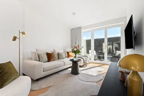 Gemütliches Wohnzimmer im Hotel Stadt Hamburg mit stilvollem Sofa, Blumen und modernem Dekor.