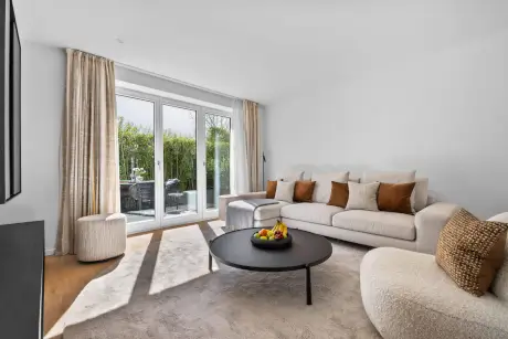Modernes Wohnzimmer mit Sofa, Couchtisch und großer Fensterfront.