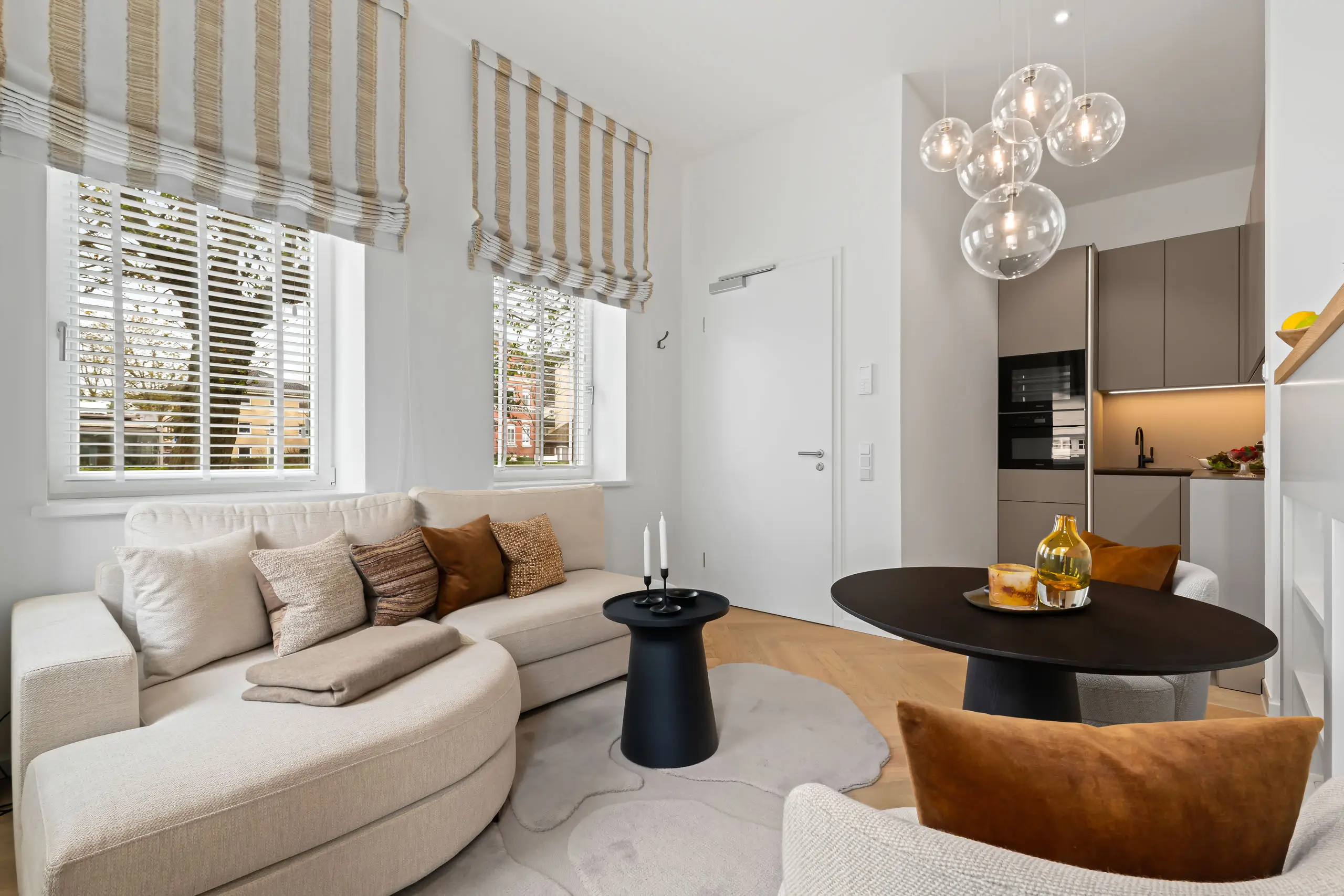 Helles modernes Wohnzimmer mit Sofa, Tisch und eleganter Beleuchtung.